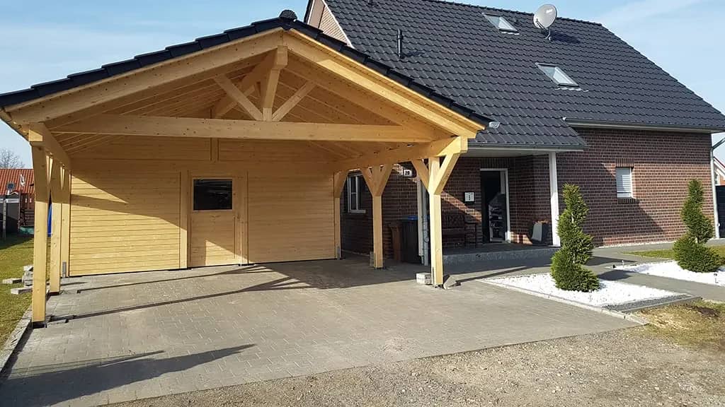 Holz-Carport mit Satteldach vor einem Einfamilienhaus